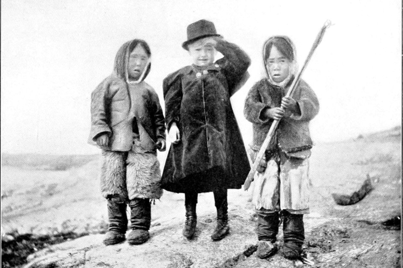 Tre barn som står ved siden av hverandre. Svart hvitt foto